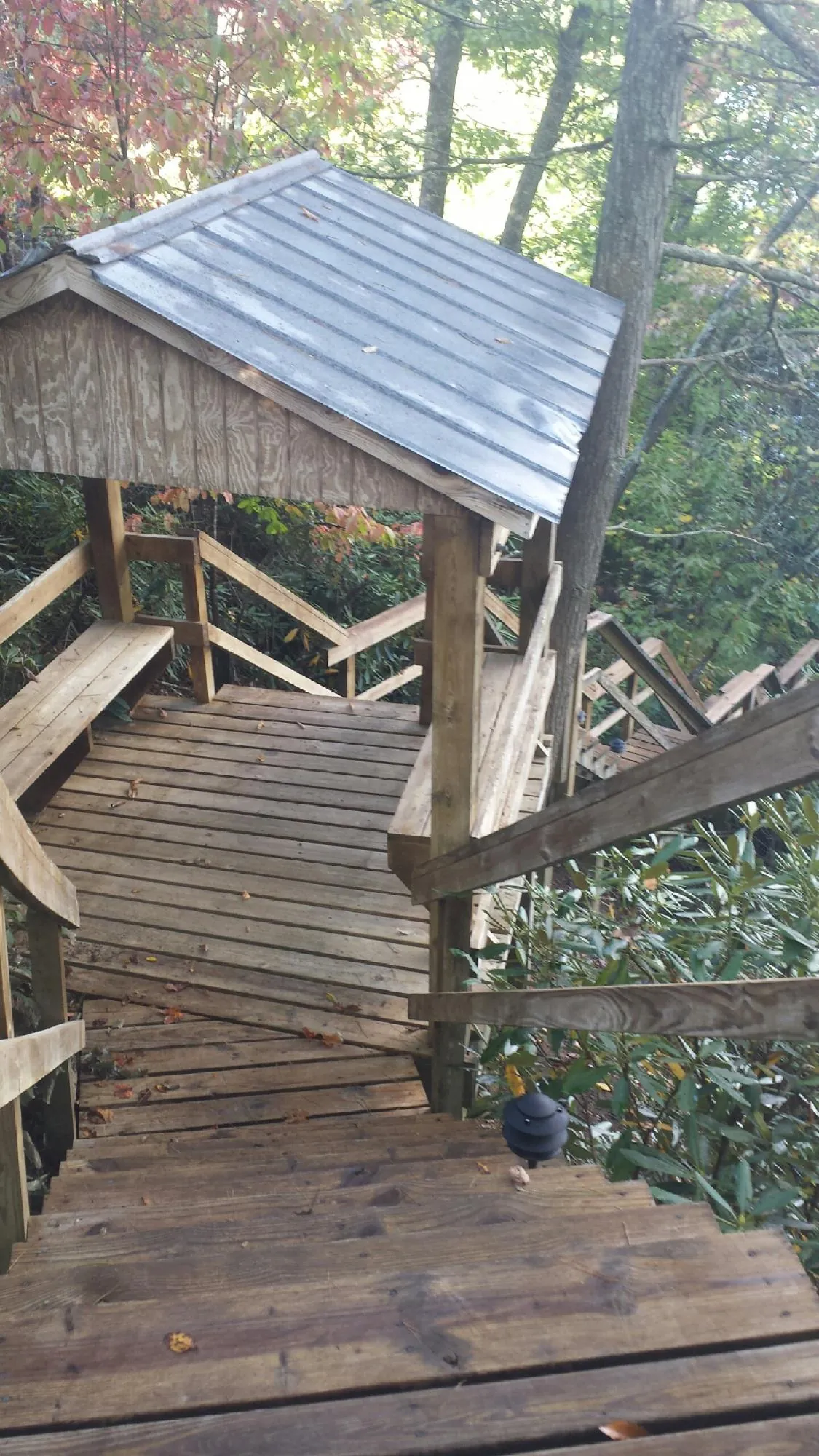 Metal roofed shelter over wooden steps on a wooded walkway — Skylight Repair & Installation work by our crew in Sugar Grove