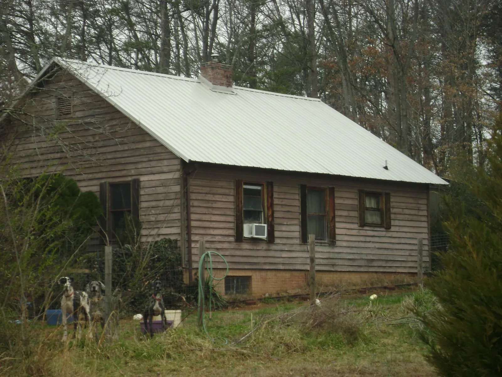 White metal roof on an old wood sided farmhouse, from a Metal Roof Installation job in Sugar Grove